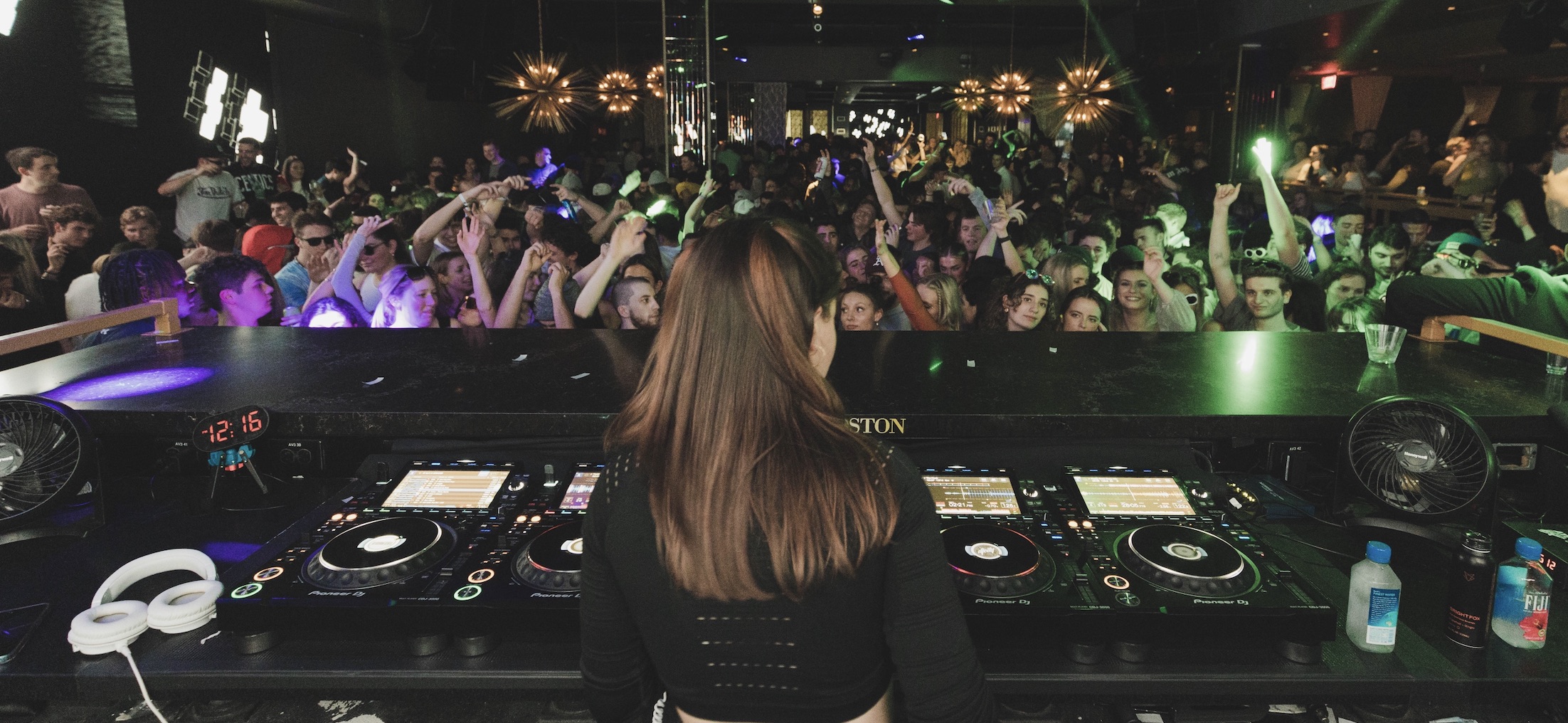 Maisy DJing to a packed crowd from the booth